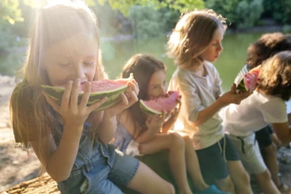 Mehrere Kinder essen Melone