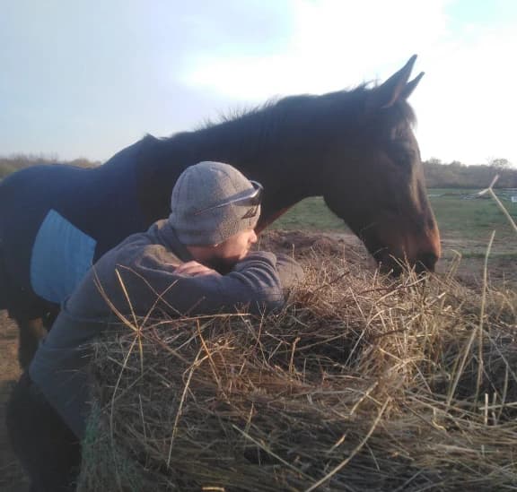 Maurice mit Pferd an Heuballen